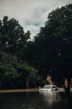 Doğal afet sırasında sel sularında mahsur kalmış gümüş renkli lüks bir araba..