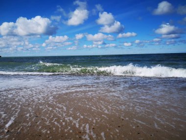 Kumlu bir sahili olan dalgalı bir denize yakın çekim