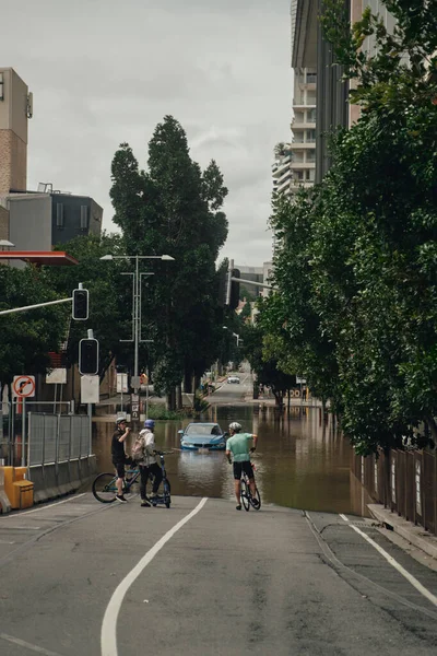 Vertical Shot Cyclists Assessing Road Conditions Heavy Rainfall Brisbane City — Stock Photo, Image