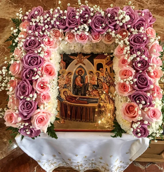 The Dormition of the Mother of God icon with flowers