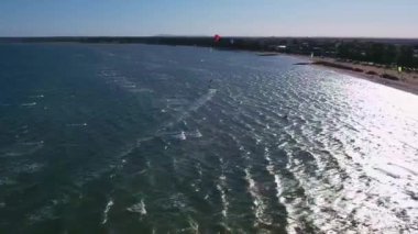 Açık deniz ve turistlerle dolu bir plajın insansız hava aracı görüntüleri.