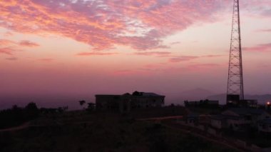 Berekuso, Gana 'da ufukta pembe bulutlu gökyüzü olan orman ağaçları ve elektrik tellerinin hava manzarası.