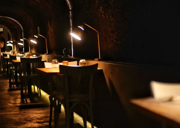 An interior of restaurant with furniture and glowing lamps