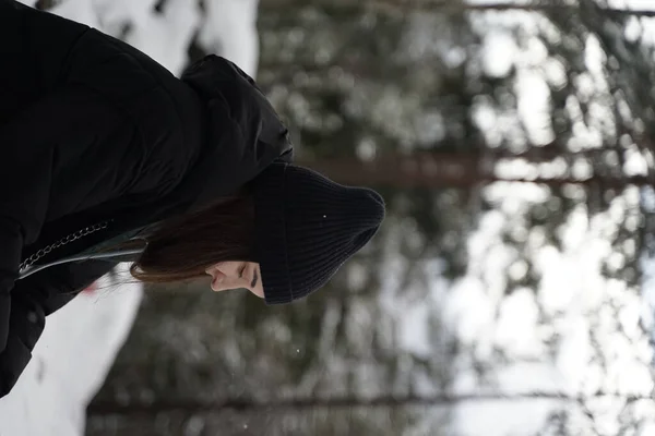 一个年轻女子在冬季森林中的垂直镜头 — 图库照片