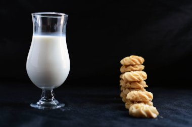 Bir bardak süt ve yanında da bir kase bisküvi. Lezzetli görünüyor.