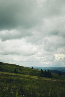 Bulutlu bir gökyüzünün altındaki dağların nefes kesici manzarası.