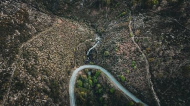 Çin 'in yemyeşil tepelerindeki eğimli bir yolun havadan görünüşü.
