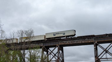 Metal köprüdeki tren vagonları bulutlu gökyüzüne karşı. Altavista. Amerika Birleşik Devletleri.