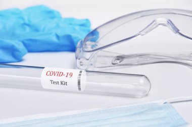 Beyaz masa arkaplanındaki covid-19 test kitinin yakın çekimi.