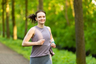 Genç bir dişi ormanda koşuyor.