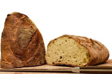 Mutfaktaki ahşap kesme tahtasının üzerinde taze pişmiş ekmek.