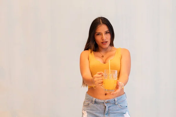 Latinamerikansk Tjej Med Orange Topp Som Håller Ett Glas Juice — Stockfoto