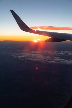 Gün batımında bir uçağın kanadının penceresinden güzel bir çekim.