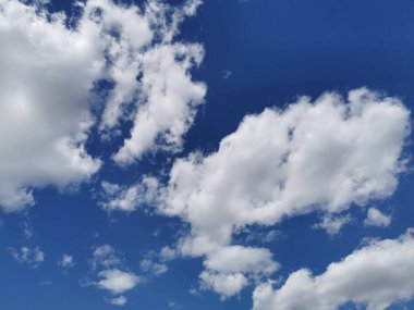 Berrak gökyüzünde beyaz kabarık bulutların güzel bir manzarası