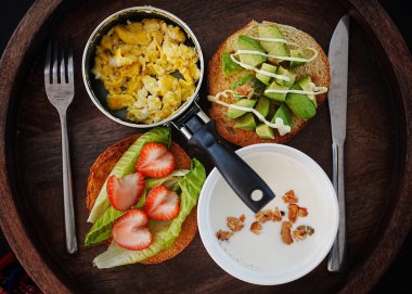 Tavada çırpılmış yumurta, tostun üstünde çilek ve marul ve tostun üstünde avokado.