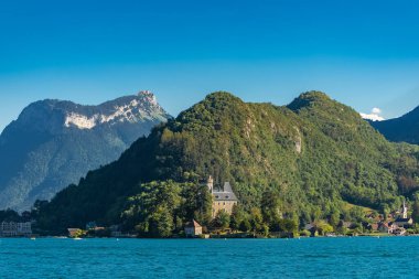 Fransa 'daki Annecy, göldeki Duingt kalesi ve Saint-Jorioz köyü.