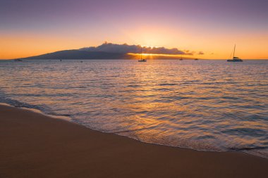 Kaanapali sahilinden veranda adasının üzerinde gün batımı görüntüsü.