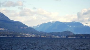 Arka planda tepeler olan güzel bir deniz görüntüsü.