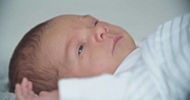 Yeni doğmuş güzel bir kız bebek yatakta yatıyor.