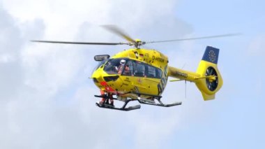 Havada süzülen sarı ADAC kurtarma helikopteri, Alman acil durumu, arama kurtarma altyapısı.
