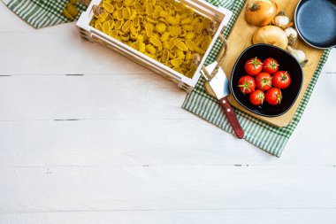 Telif alanı olan beyaz bir masanın üzerindeki İtalyan makarna malzemelerinin üst görüntüsü.