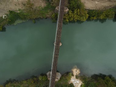 Nehrin yukarısındaki bir köprünün havadan görünüşü kıyılarından yeşilliklerle kaplıydı.