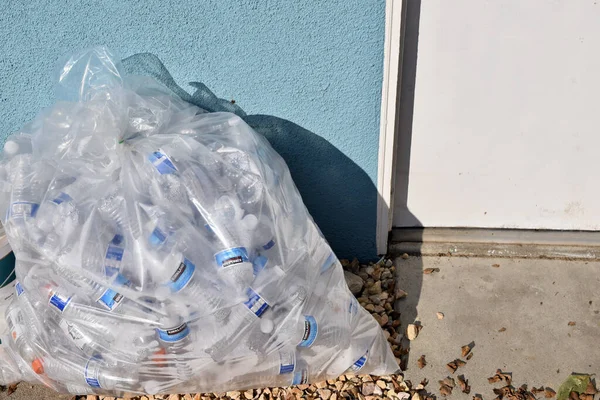 Clear Bag Full Empty Water Bottles Ground Blue Wall — Stock Photo, Image