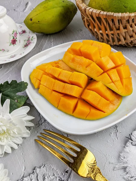 Obierane Mango Białym Talerzu Koszem Pełnym Mango Złotym Widelcem Obok — Zdjęcie stockowe