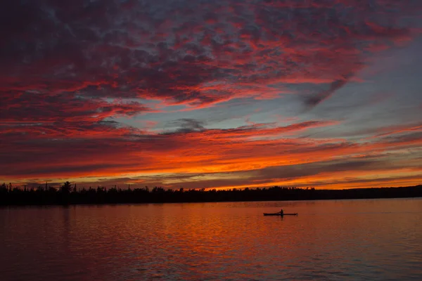 カラフルな曇りの空の下でカヤックと池の魅惑的な夕日の景色 — ストック写真