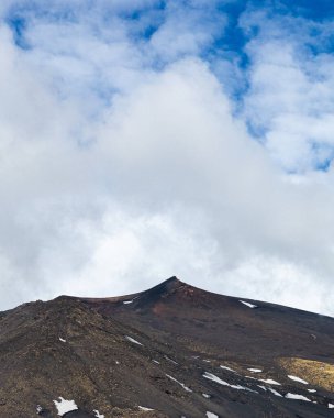 Bulutlu bir gökyüzünün altındaki dağlık bir arazinin güzel bir görüntüsü.