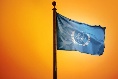 Uluslararası Atom Enerjisi Ajansı 'nın parlak sarı gökyüzüne el sallayan bayrağının dijital bir çizimi.