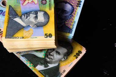 Karanlık bir yüzey - dünya para kavramı üzerine bir yığın LEI Romen banknotunun yakın çekimi