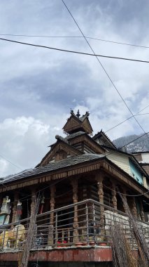 Manali 'de mavi parlak gökyüzünün altındaki tahta tapınağın dikey görüntüsü.