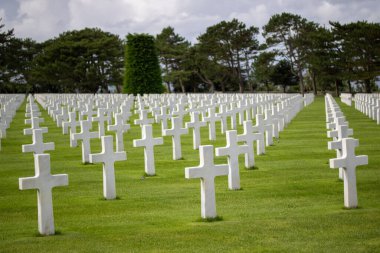 Bulutlu gökyüzünün altındaki Normandiya Amerikan Mezarlığı ve Anıtı