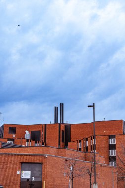 Hamilton 'da bulutlu bir günde bacalı kırmızı bir binanın dikey görüntüsü.