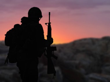 Gün batımında silahlı bir askerin silueti.