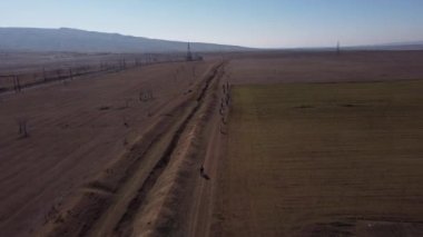 Ufukta mavi gökyüzü olan Kumisi gölü yakınlarındaki birçok bisikletçinin hava görüntüsü.