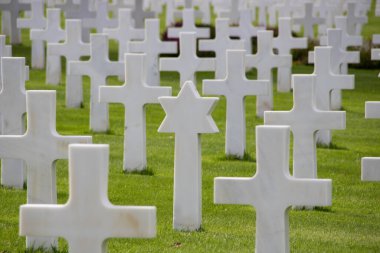 Normandiya Amerikan Mezarlığı 'nda bir Yahudi mezarı ve bulutlu gökyüzünün altında bir anıt.