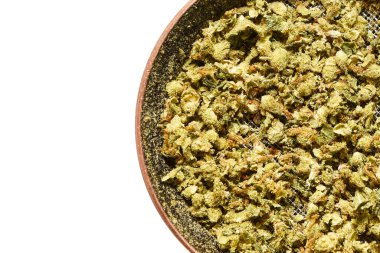 Beyaz bir arka planda izole edilmiş öğütücüdeki marihuana tomurcuklarının yakın plan çekimi.