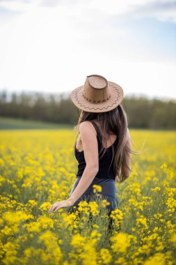 Gün ışığında tarlada poz veren çekici bir kızın yakın çekimi.