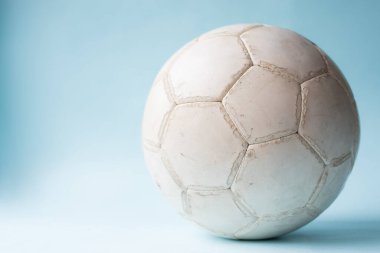 Açık mavi arka planda eski bir futbol topunun yakın çekimi