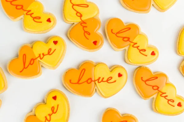 Some heart-shaped cookies with love written on them isolated on a white background