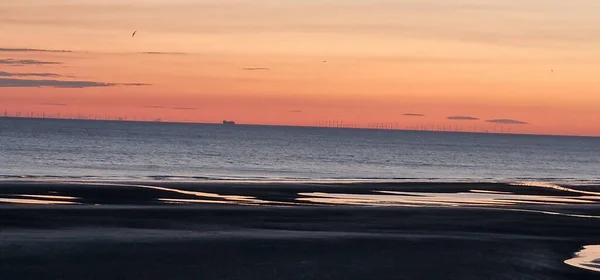 砂浜と穏やかな海の波が美しい夕日を眺めながらの魅惑的な景色 — ストック写真