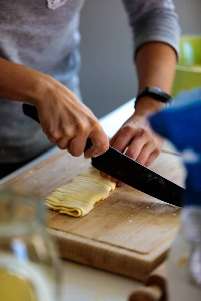 台所でナイフで生地を切断する人の垂直ショット — ストック写真