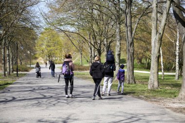 Güneşli bir günde Polonya 'nın Poznan kentindeki Cytadela Parkı' nda yürüyen insanların manzarası.