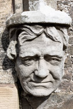 Kır evine insan yüzünün detaylı bir taş oyması.