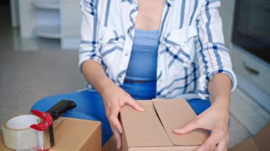 Odadaki kutuları paketleyen bir kadın.