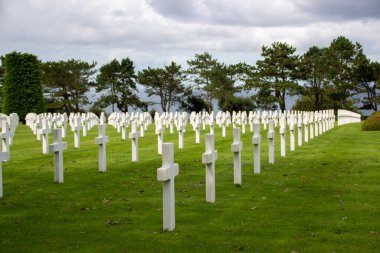 Bulutlu gökyüzünün altındaki Normandiya Amerikan Mezarlığı ve Anıtı