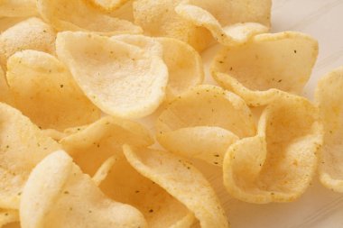 Ahşap arka planda lezzetli patates cipsi atıştırmalıkları.