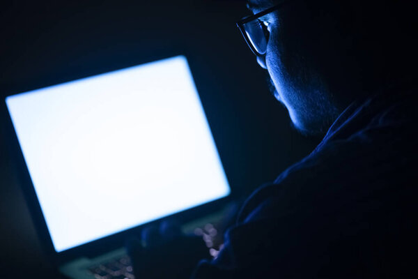 Бизнесмен, сидящий на клавиатуре ноутбука поздней ночью